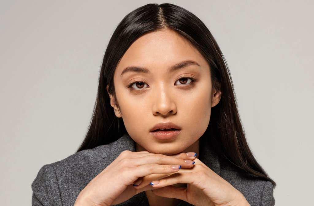Example of a photo we captured for personal branding photography, a female model in a black shirt taking a photo using a gray background